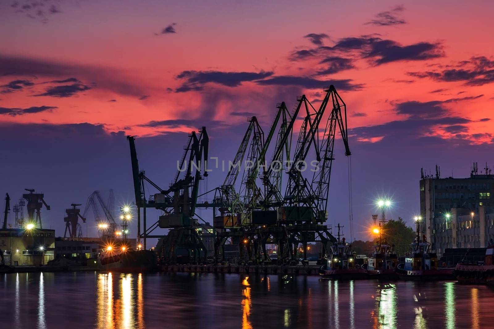 the silhouette of port cranes, at stunning twilight 