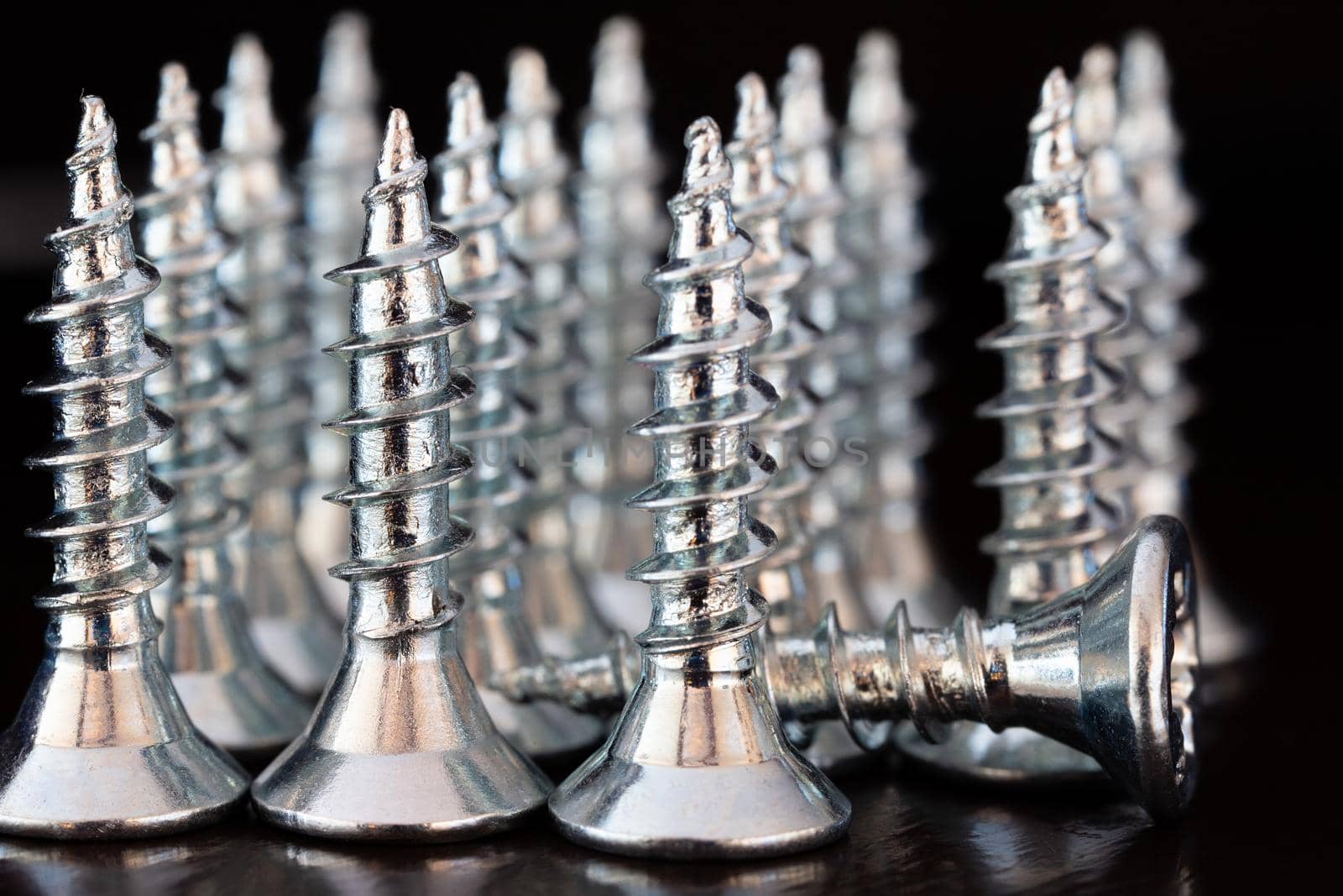 Close up of screws on a black background. Advertising photo