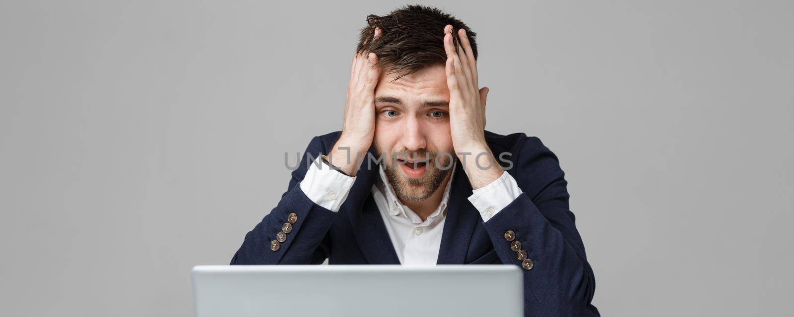 Business Concept - Portrait handsome stressful business man in suit shock looking at work in laptop. White Background.