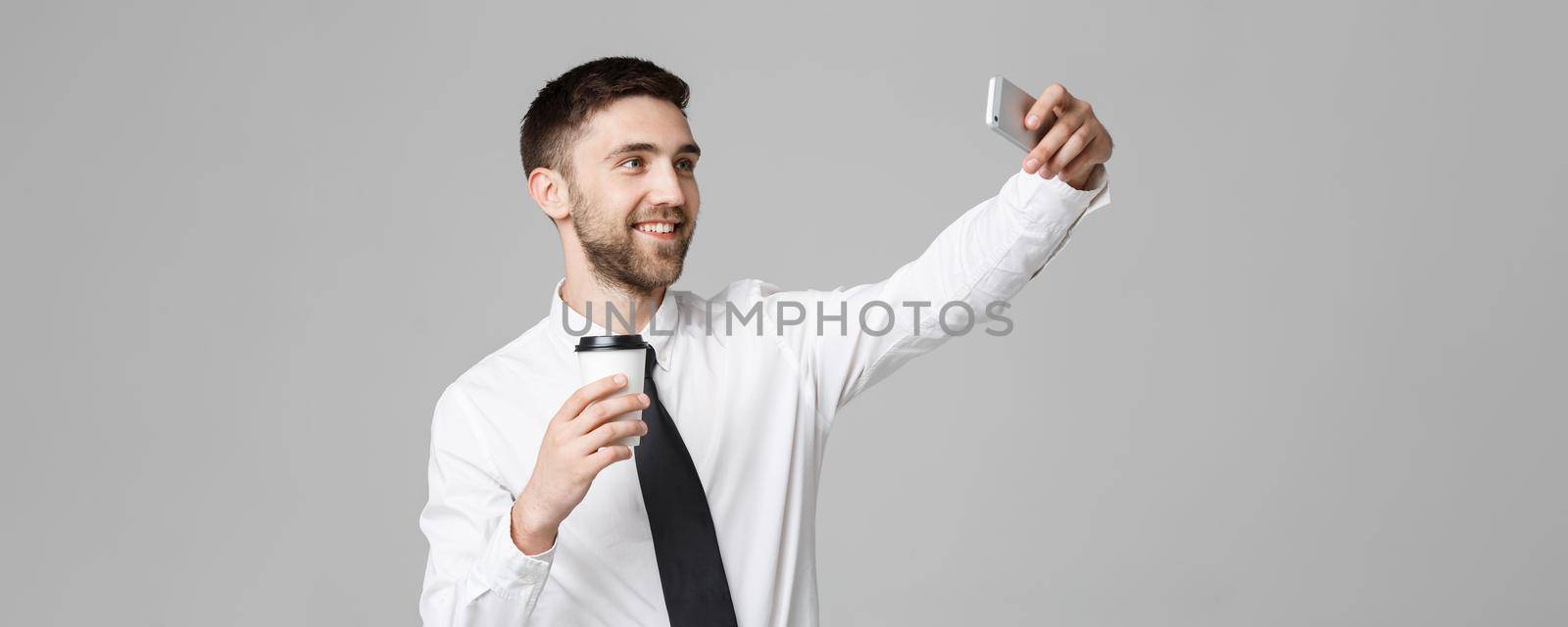 Lifestyle and Business Concept - Portrait of a handsome businessman enjoy taking a selfie with take away cup of coffee. Isolated White background. Copy Space.