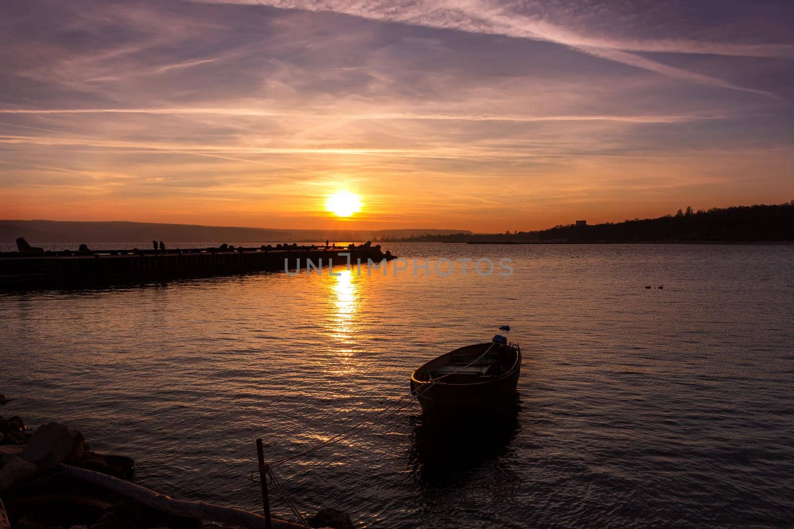 Beautiful light composition and mood of the boat in calm water at sunset