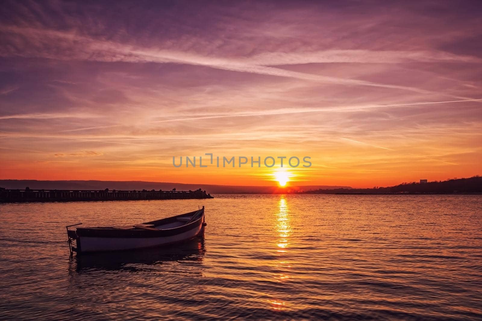 Beautiful light composition and mood of the boat in calm water at sunset
