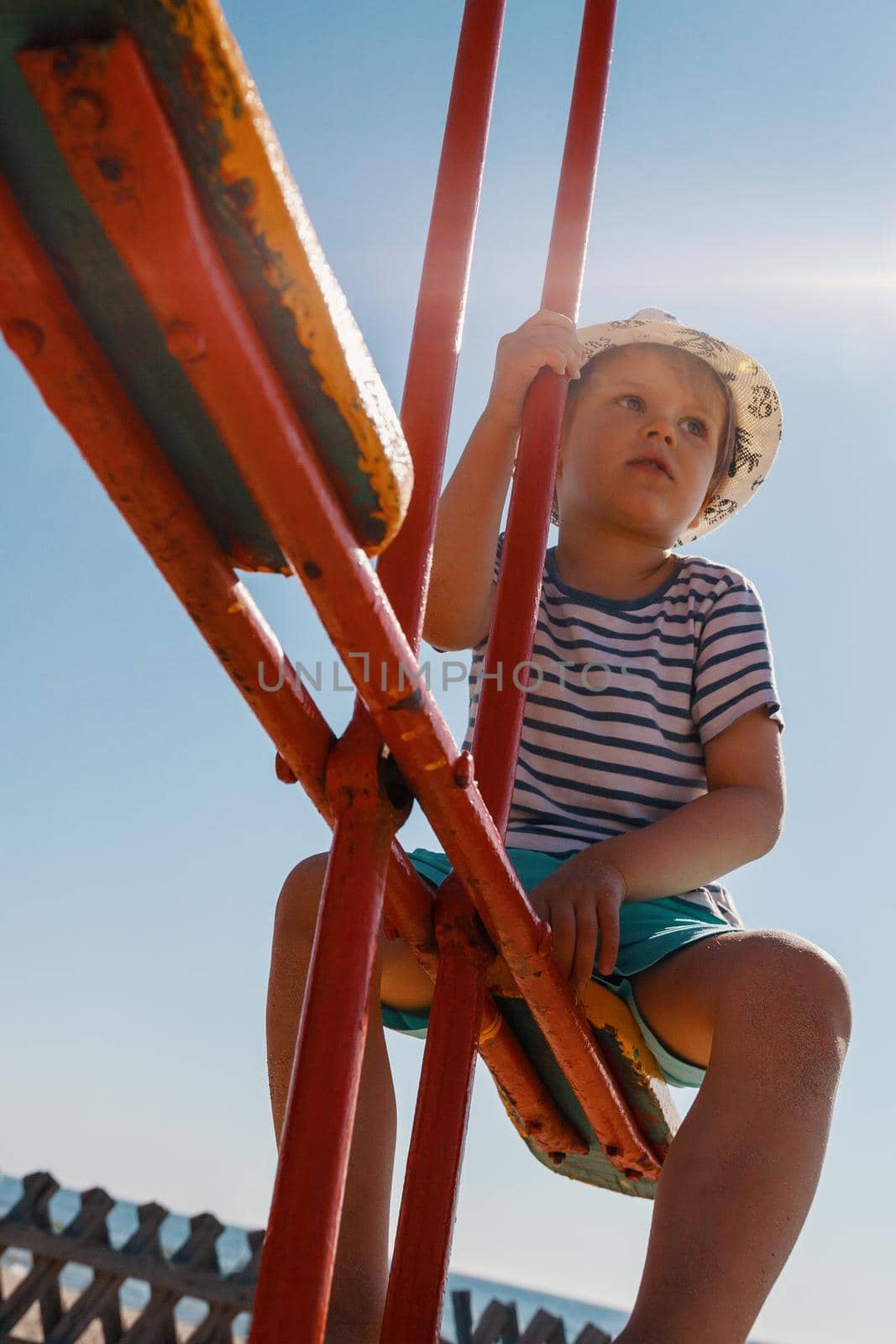 Little boy on a balance swing, bottom view