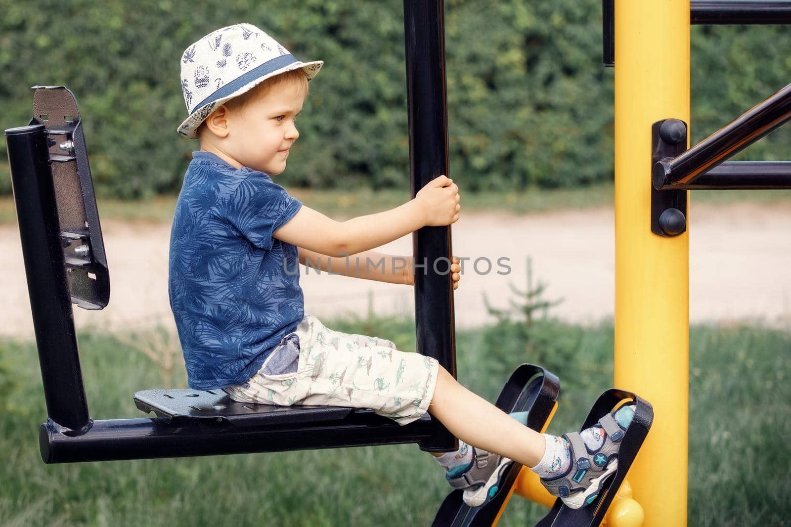 Boy child doing sports exercises on the outdoor sports ground. by Lincikas