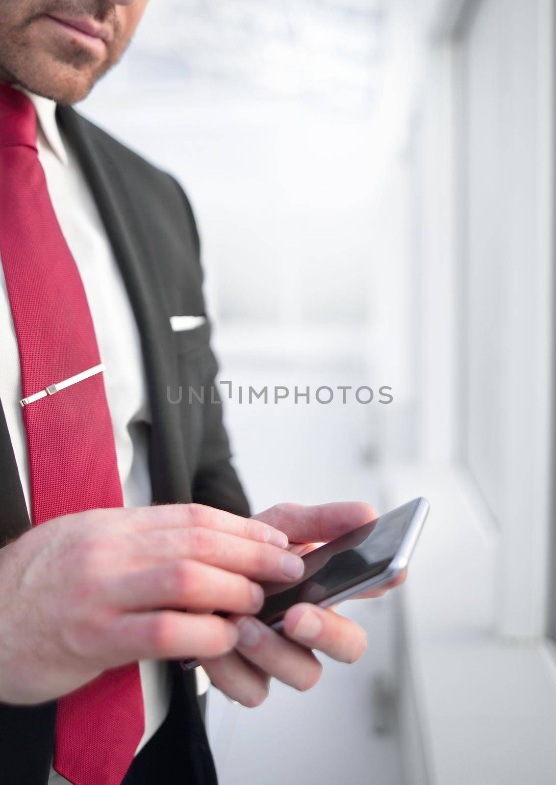 close up.businessman reading text message on smartphone by asdf