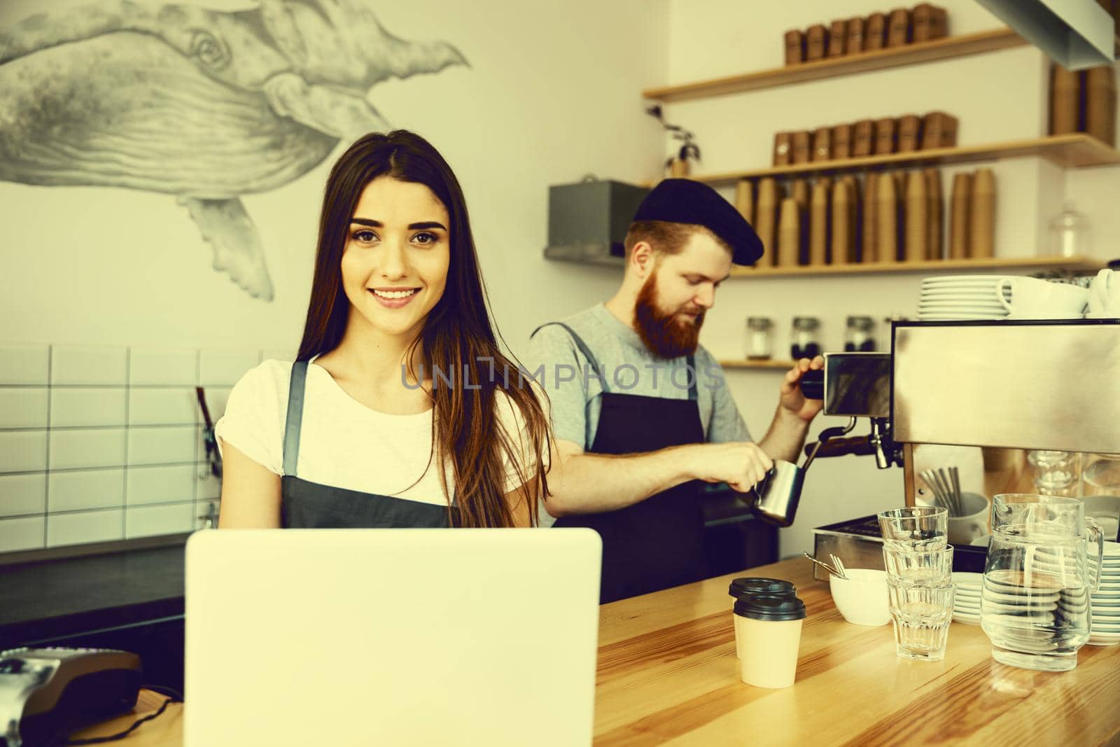 Coffee Business Concept - beautiful caucasian bartender barista or manager working and planing in laptop at modern coffee shop