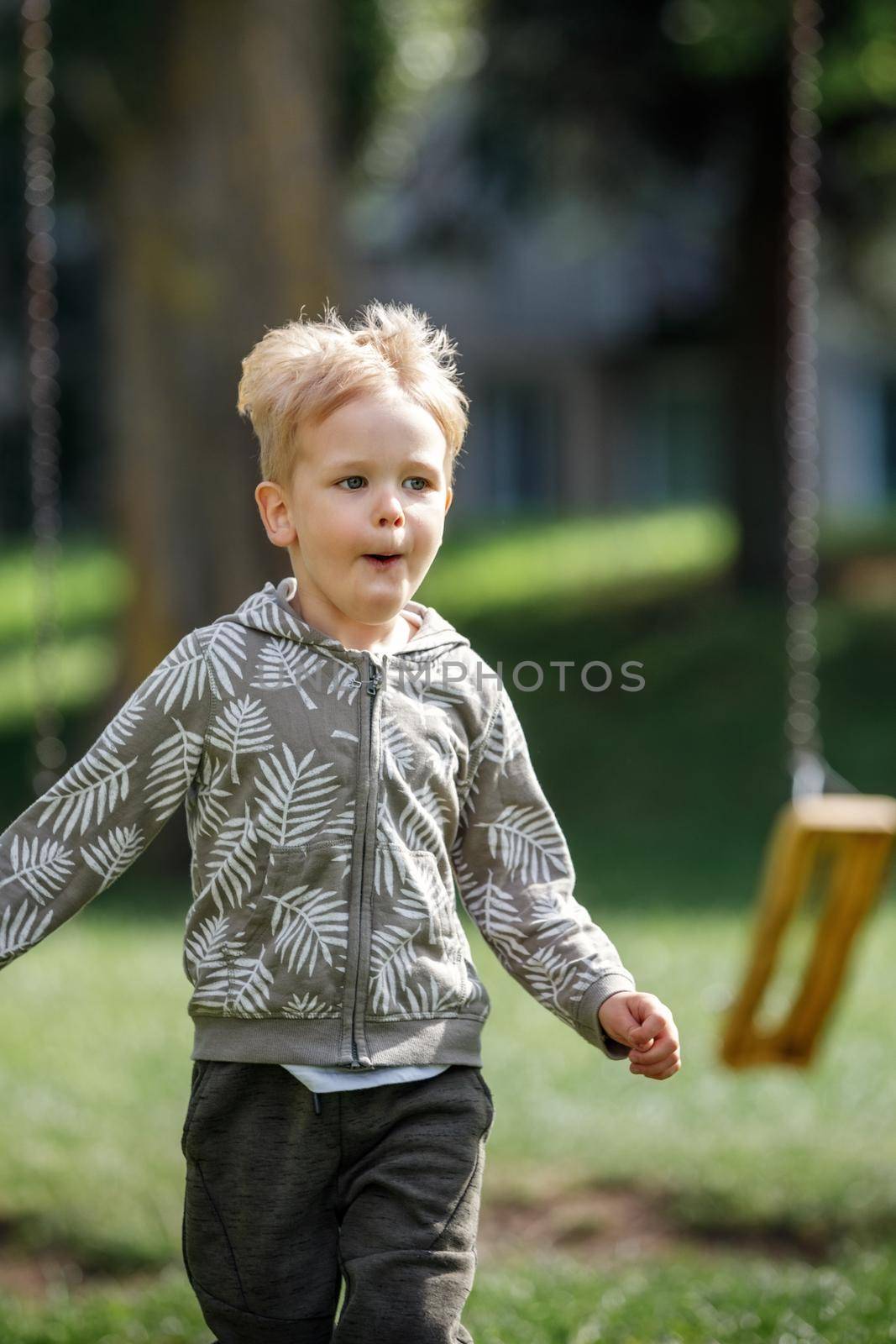 Adorable little boy running towards camera. Vertical photo. by Lincikas