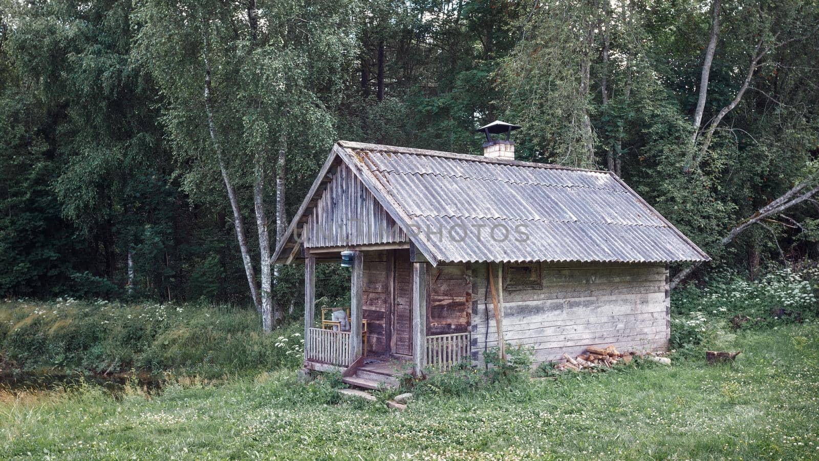 Old and abandoned bathhouse in an overgrown meadow, country forest, Lithuania