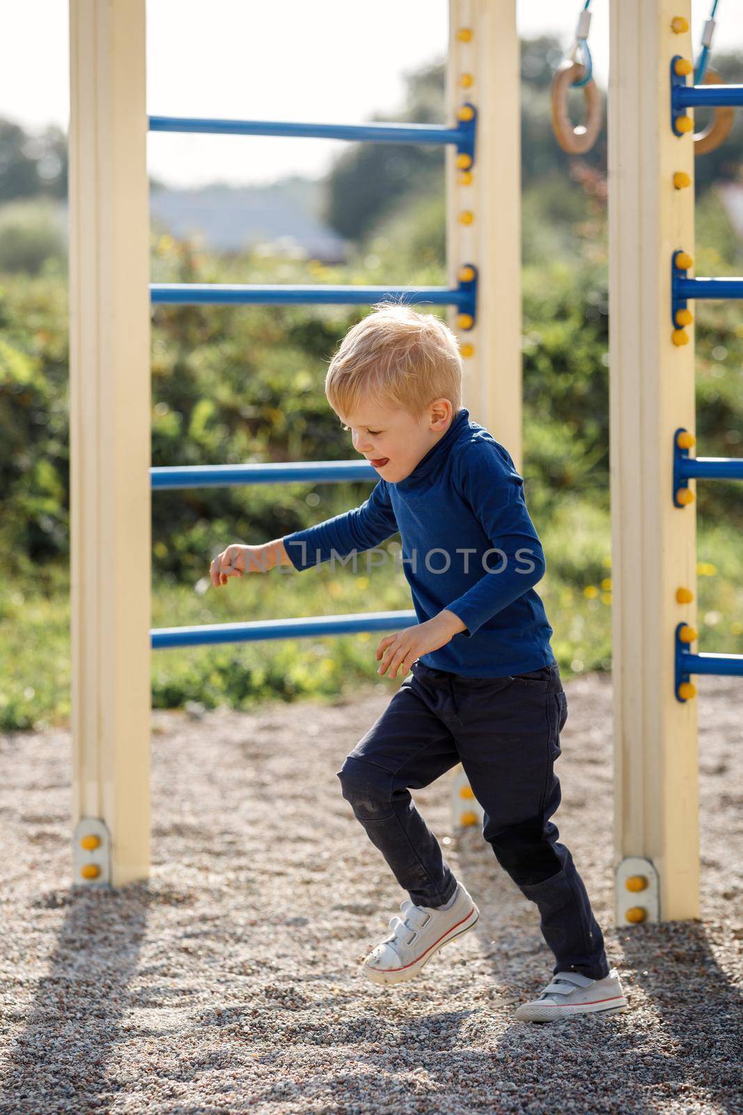 The little boy starts run forward outside on a playground on a summer day. The concept of child sport and active in fresh air by Lincikas