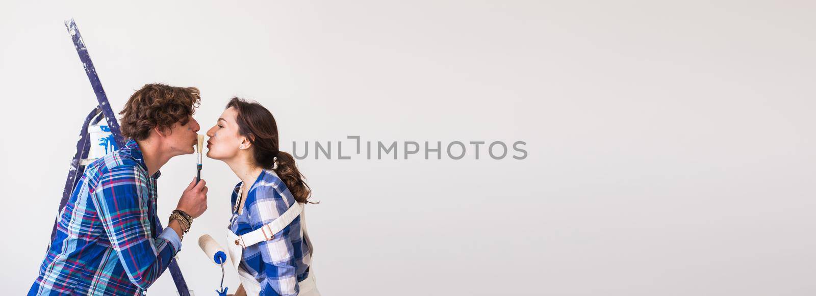 Renovation, redecoration and people concept - Lovely kissing young couple doing repairs apartment banner white background with copy space and place for advertising by Satura86