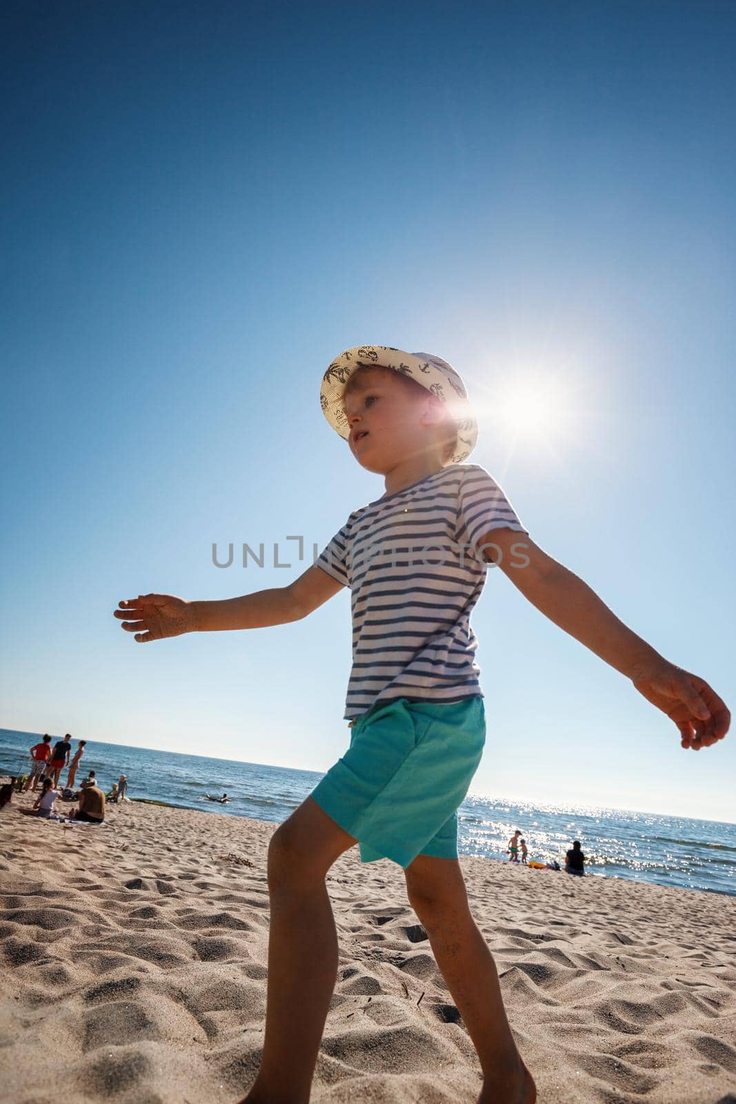 Adorable little boy on the sand beach at Baltic sea Lithuania. Small child enjoying vacation by the sea. Travelling with kids