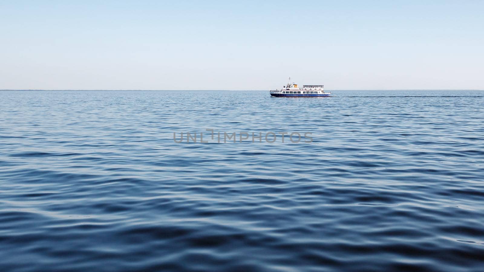 Blue lagoon, blue sky, and blue tourist boat. A relaxing trip to the sea on a sunny summer day. by Lincikas