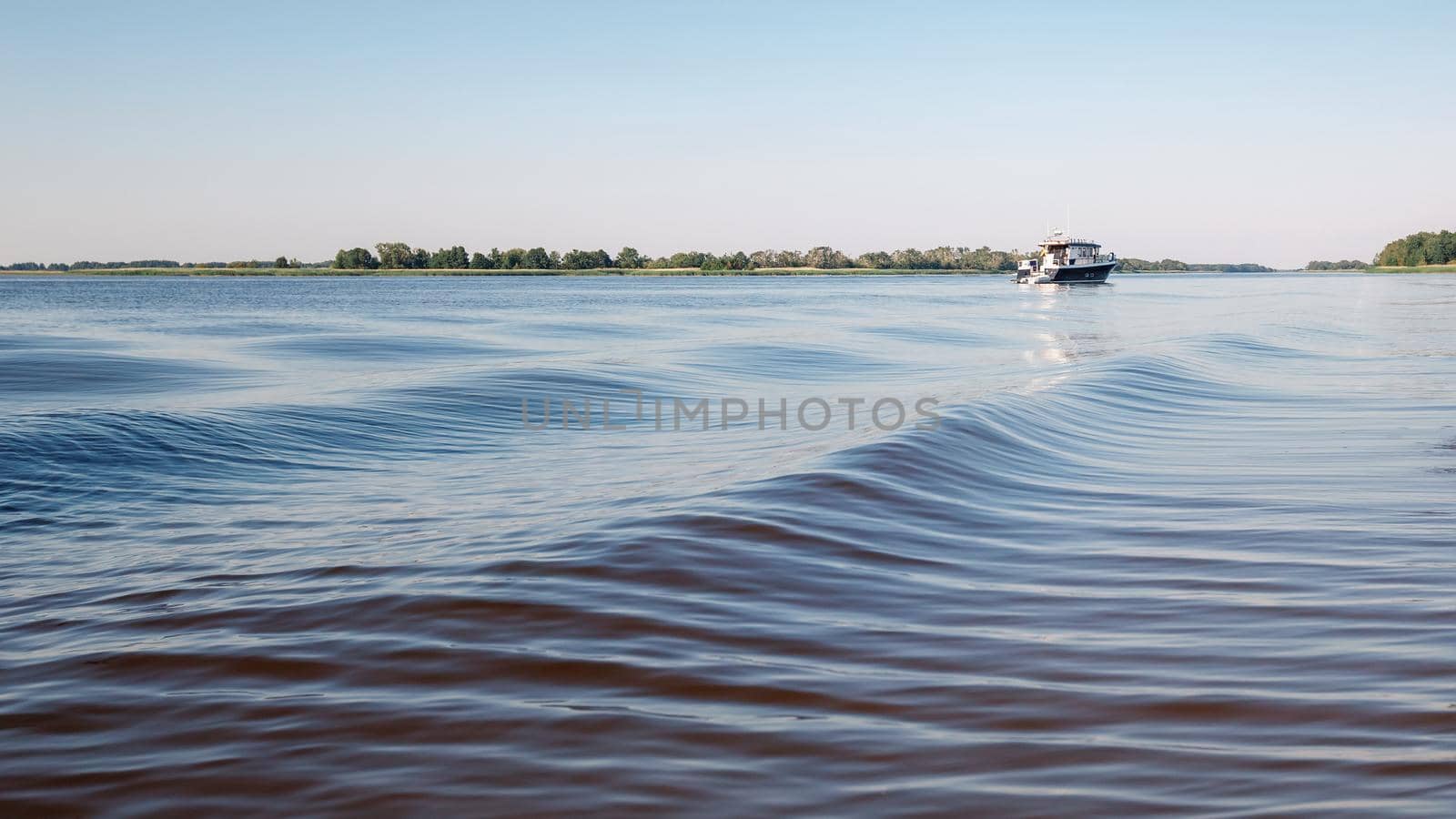 A small boat with tourists returns from a tour of the lagoon. by Lincikas