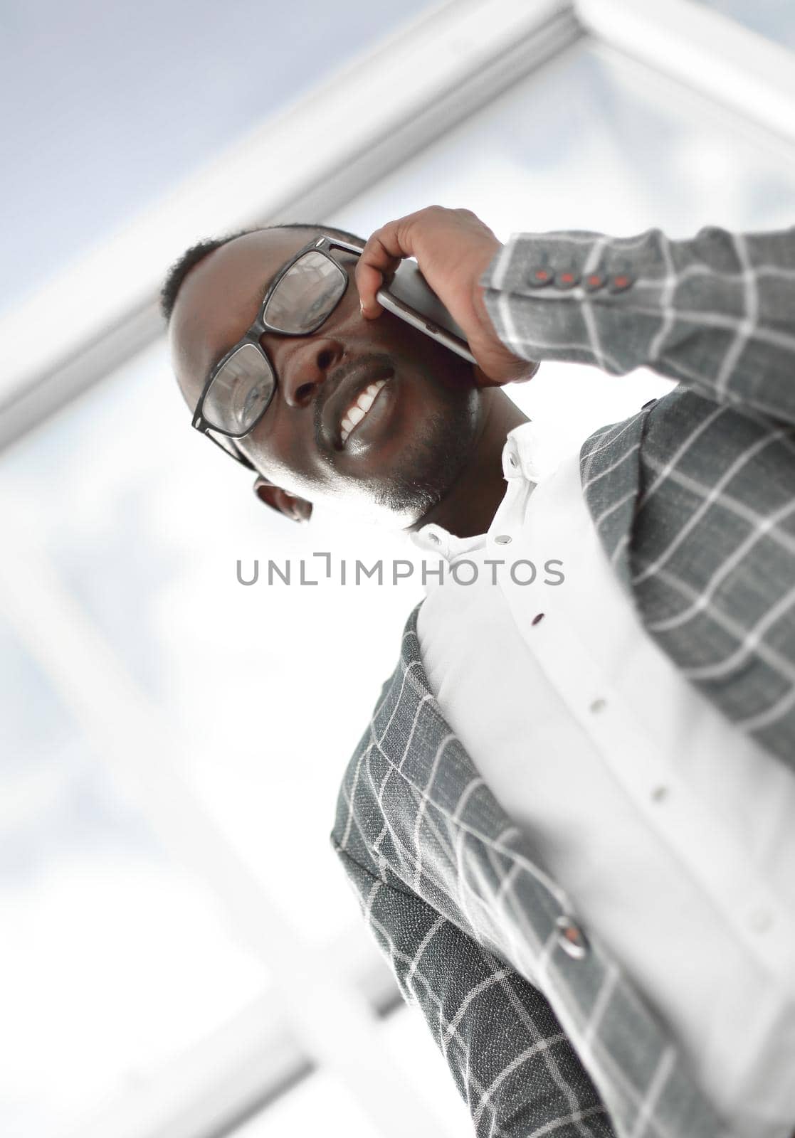 bottom view.smiling businessman talking on a mobile phone by asdf