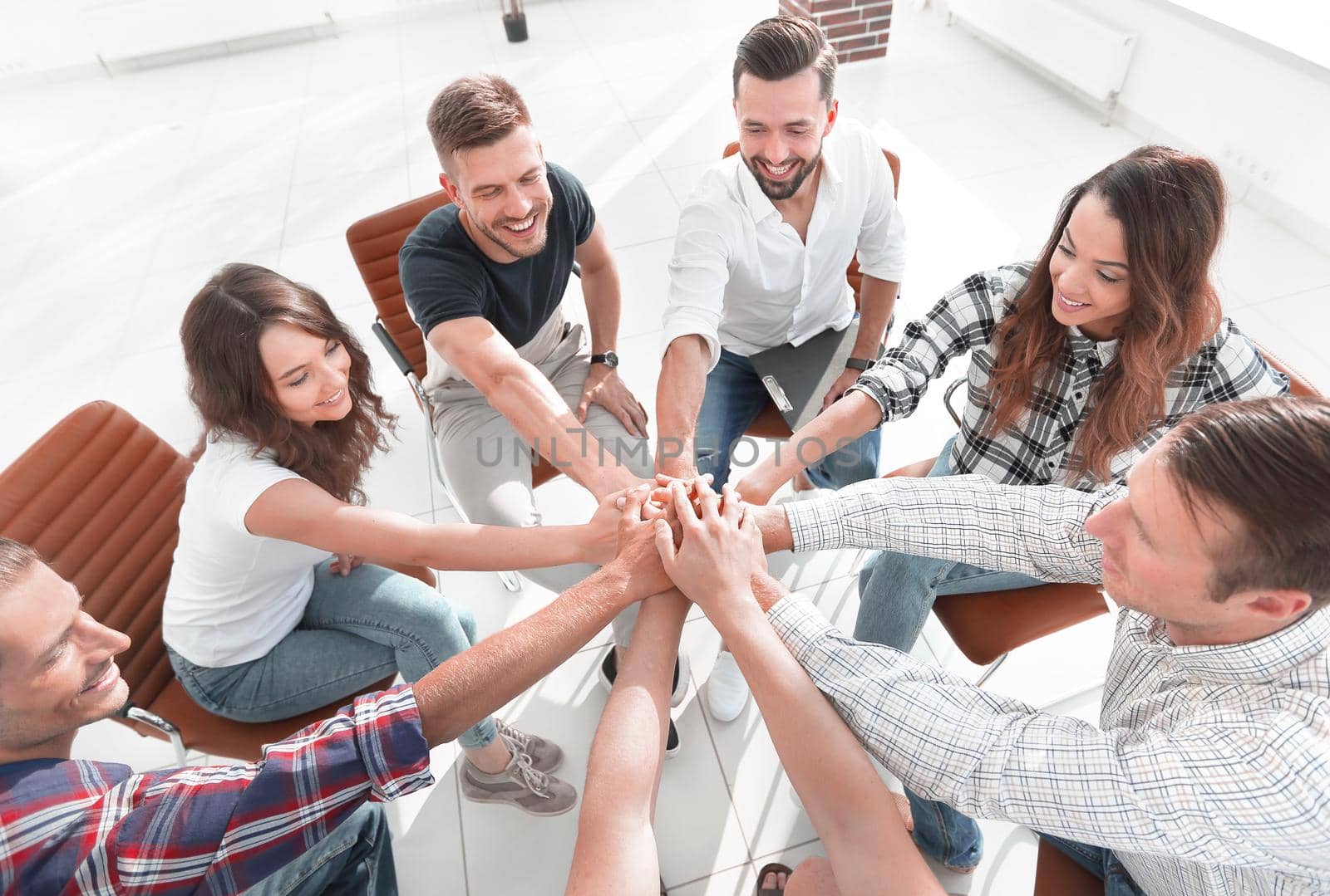 successful business team sitting in the middle of the office and hands clasped together