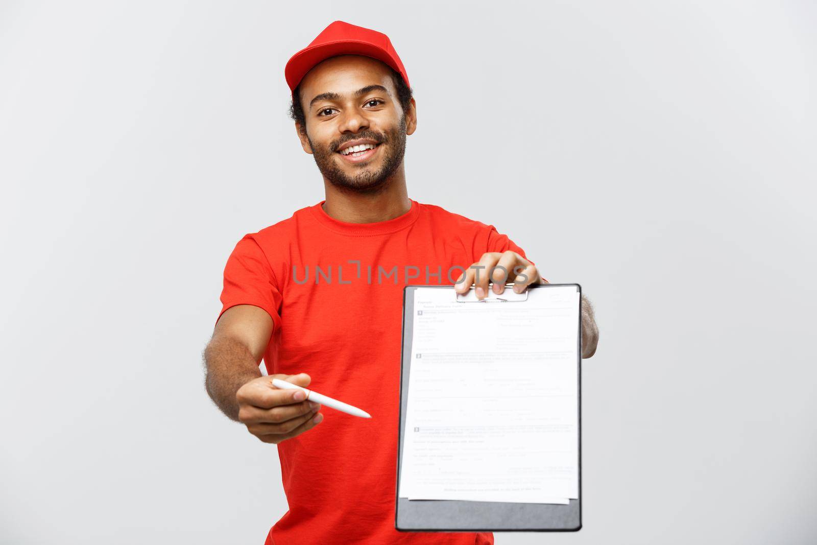 Delivery Concept - Portrait of Handsome African American delivery man or courier showing a confirmation document form to sign. Isolated on Grey studio Background. Copy Space