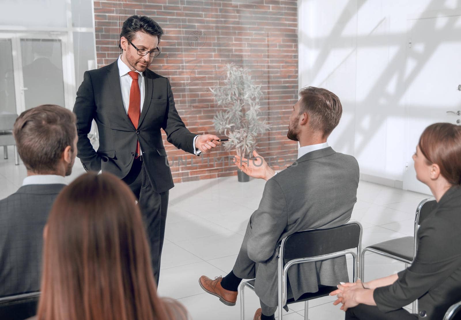 man standing in front talking to a group of business people