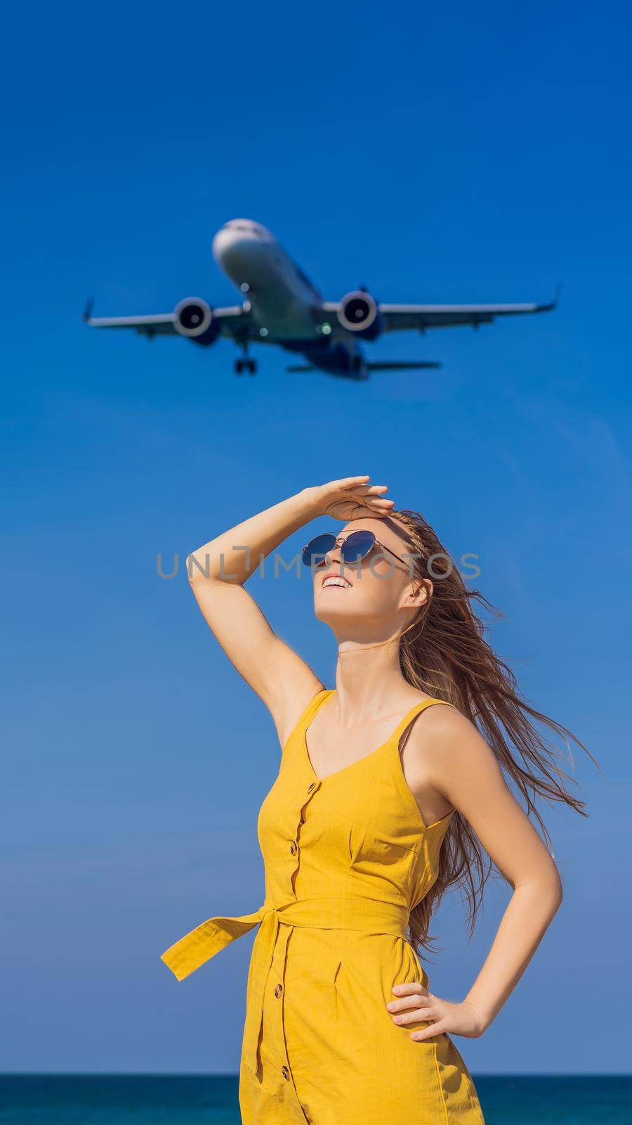 Woman have fun on the beach watching the landing planes. Traveling on an airplane concept. Text space. Island Phuket in Thailand. Impressive paradise. Hot beach Mai Khao. Amazing landscape. VERTICAL FORMAT for Instagram mobile story or stories size. Mobile wallpaper
