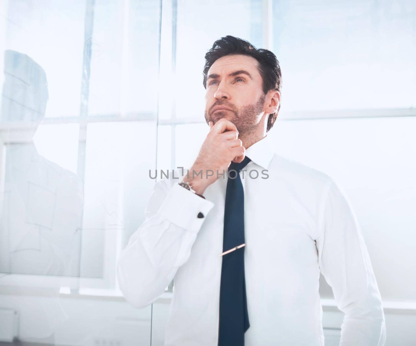 dreaming businessman standing in the office. by asdf