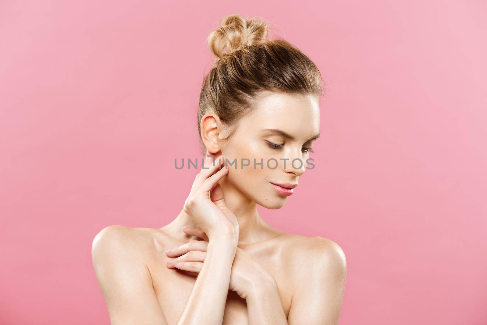 Beauty skin Concept - Beautiful Young Caucasian Woman with Clean Fresh Skin look away with pink studio background. Girl beauty face care. Facial treatment. Cosmetology , beauty and spa. by Benzoix