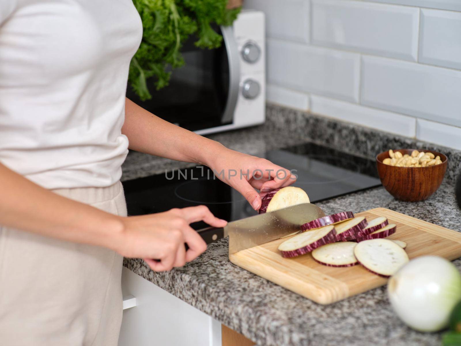 woman chopping the vegetables into slices to prepare a tabbouleh, horizontal cutout view