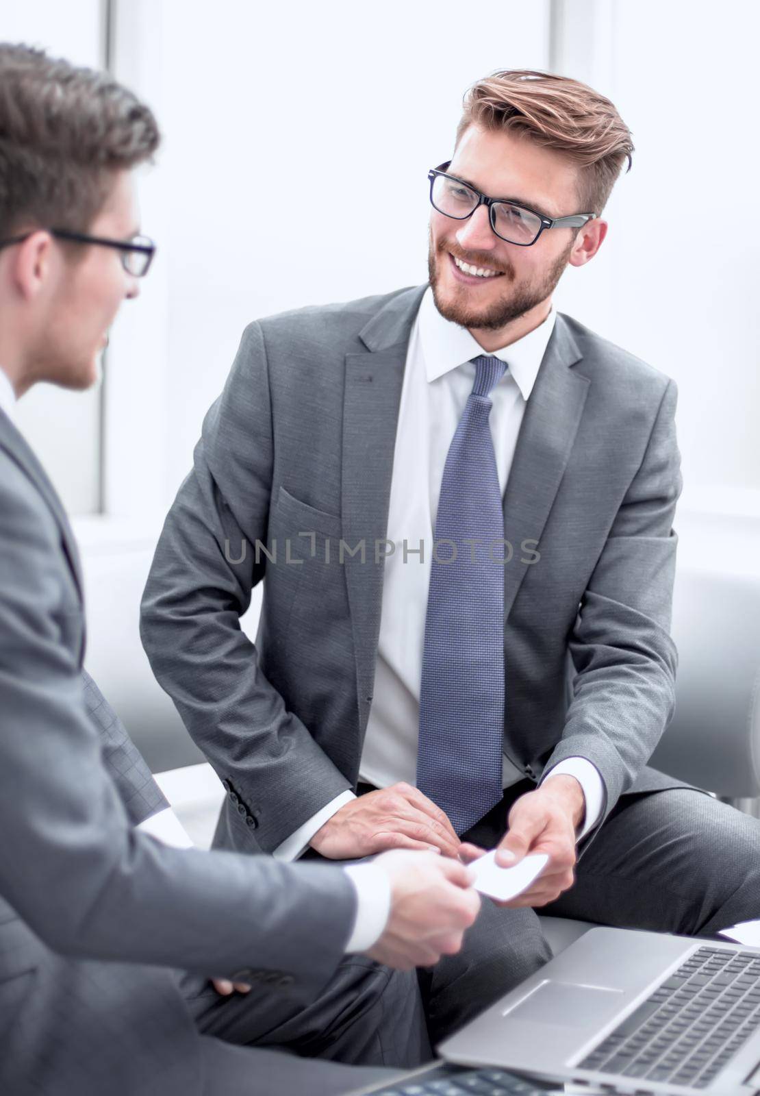 businessman gives the client a business card. concept of partnership