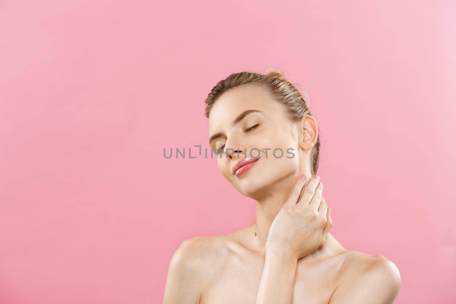 Beauty Concept - Beautiful Caucasian woman with clean skin, natural make-up isolated on bright pink background with copy space. by Benzoix