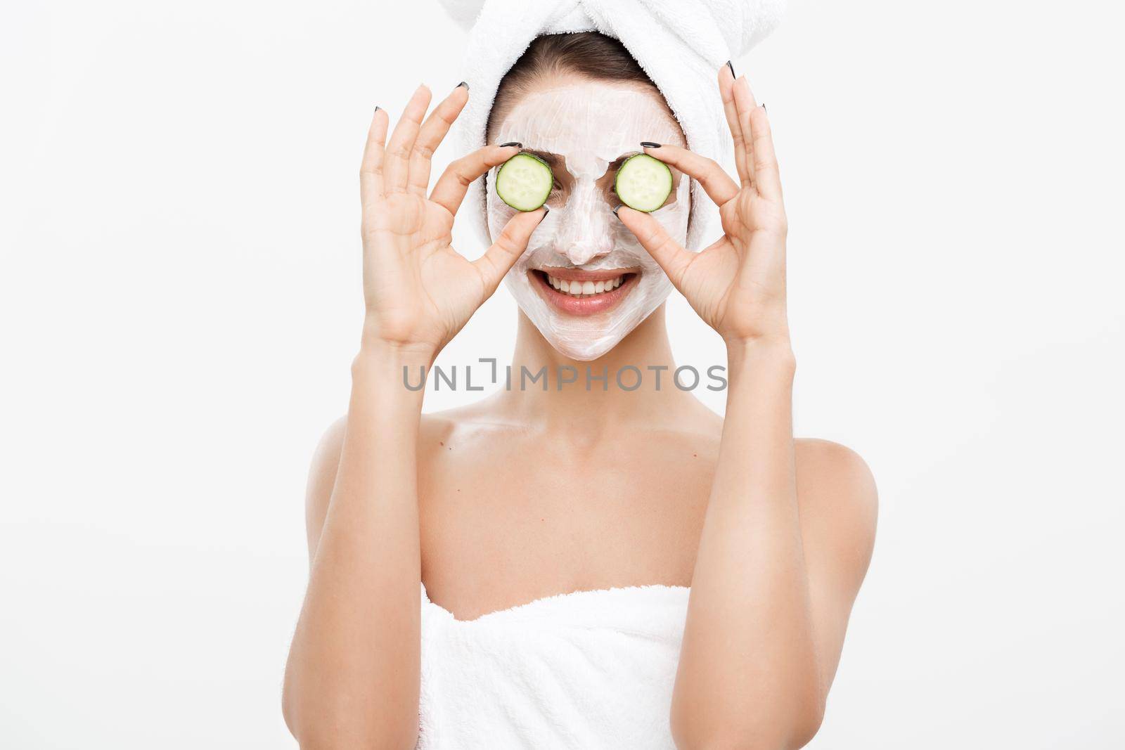 Beauty Youth Skin Care Concept - Portrait Beautiful Caucasian Woman apply cream and holding fresh cucumber in front of her face.Isolated over white background