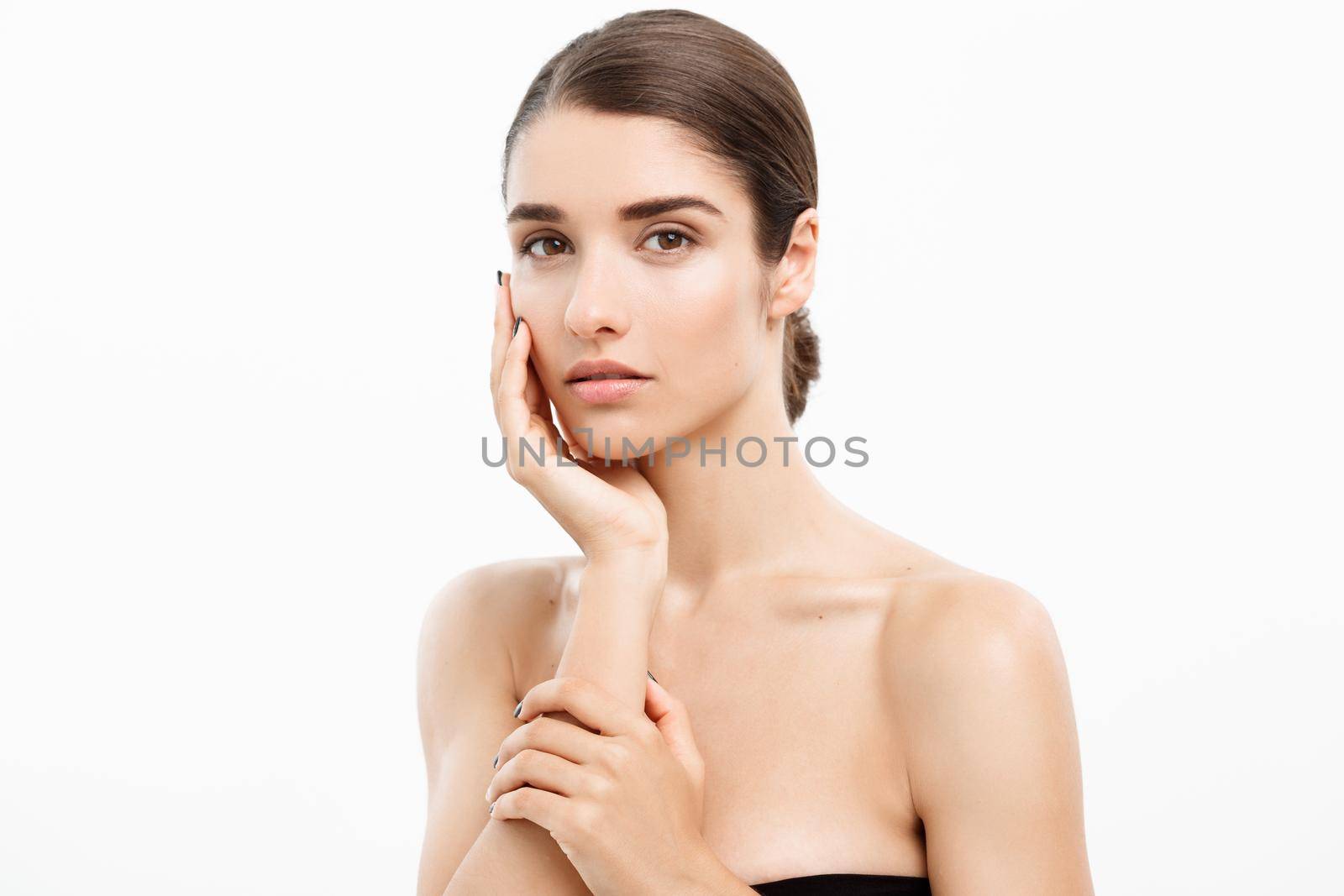 Beauty Skin Care Concept - Beautiful Caucasian Woman Face Portrait. Beautiful beauty young female model girl touching her face skin cheeks hands fingers. Fashion Beauty Model isolated on white by Benzoix