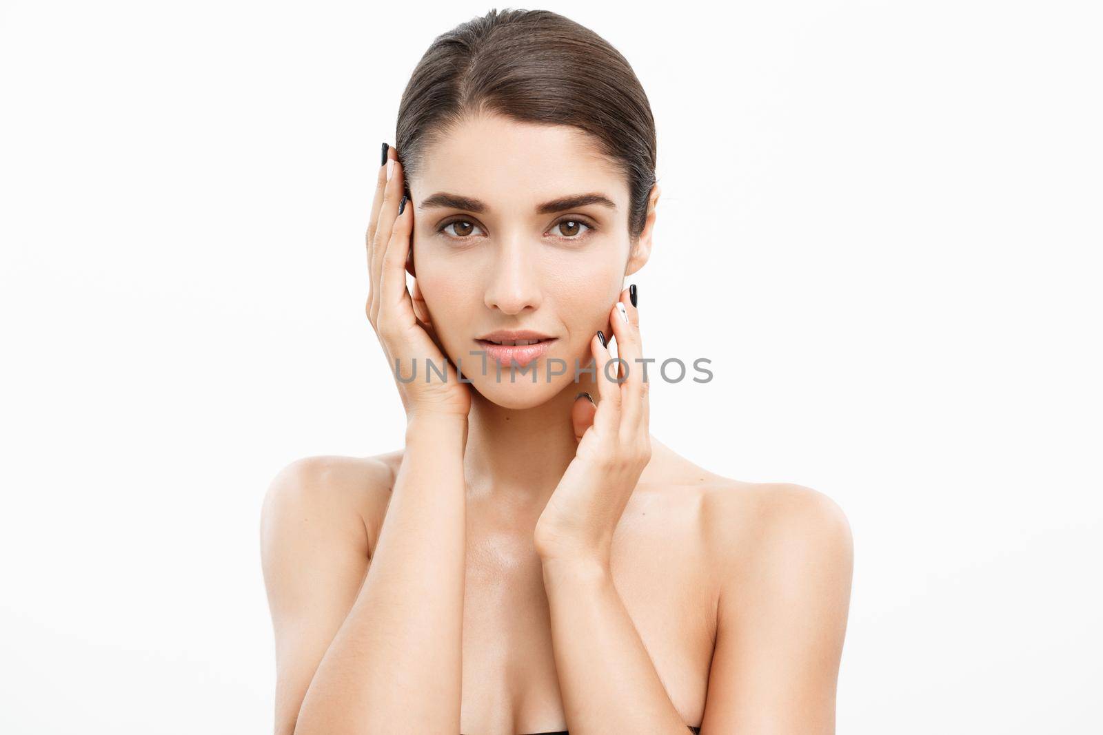 Beauty Skin Care Concept - Beautiful Caucasian Woman Face Portrait. Beautiful beauty young female model girl touching her face skin cheeks hands fingers. Fashion Beauty Model isolated on white.