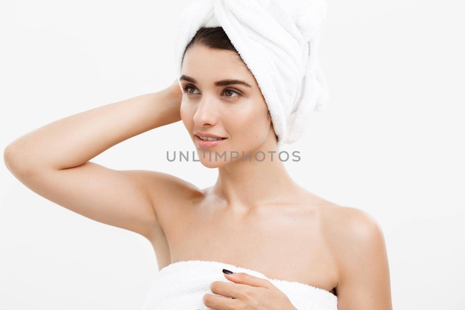 Beauty and Skin care concept - Beautiful caucasian Young Woman with bath towel on head covering her breasts, on white. by Benzoix