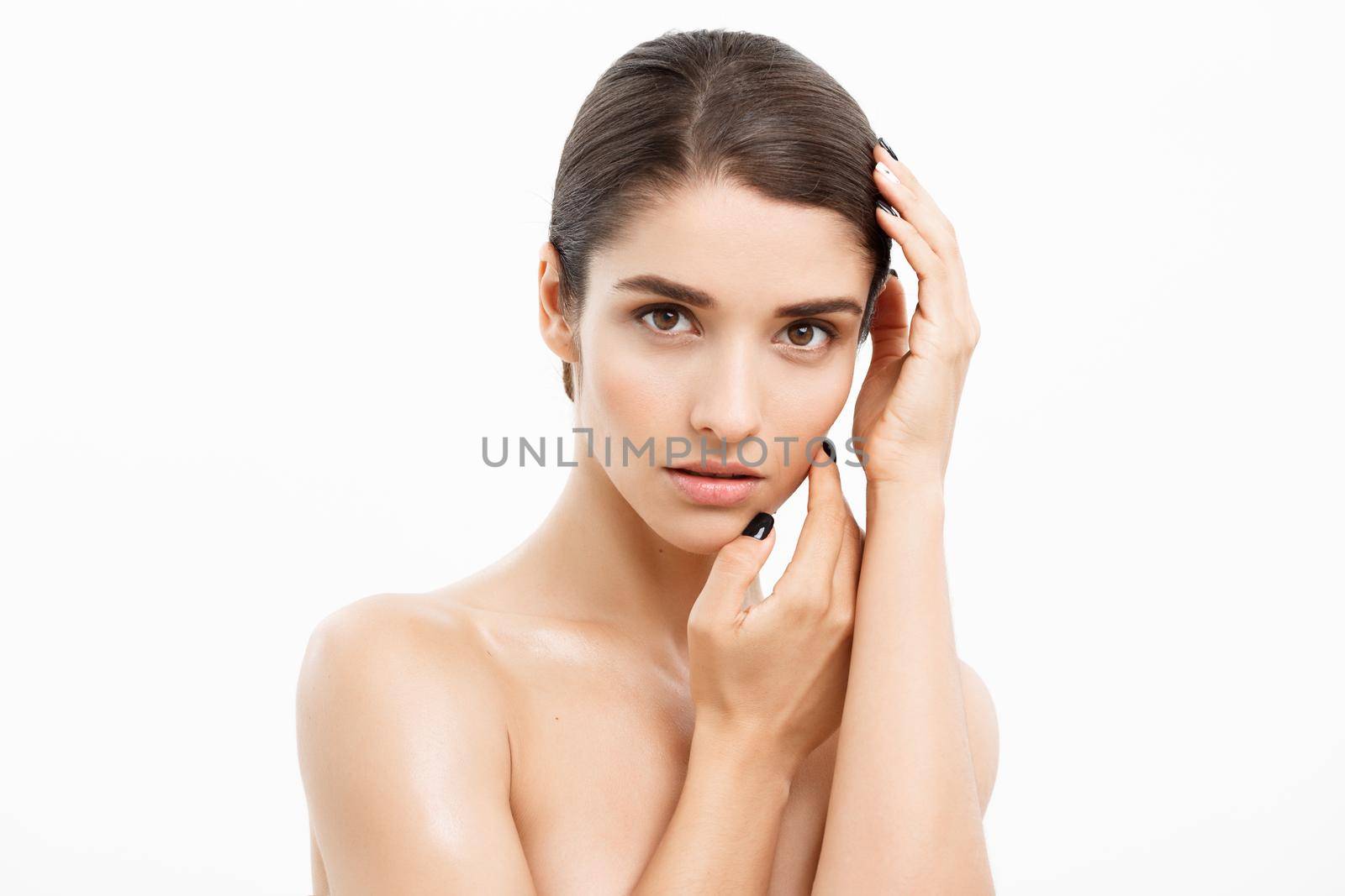 Beauty and Skin care concept - Close up Beautiful Young Woman touching her skin on white background