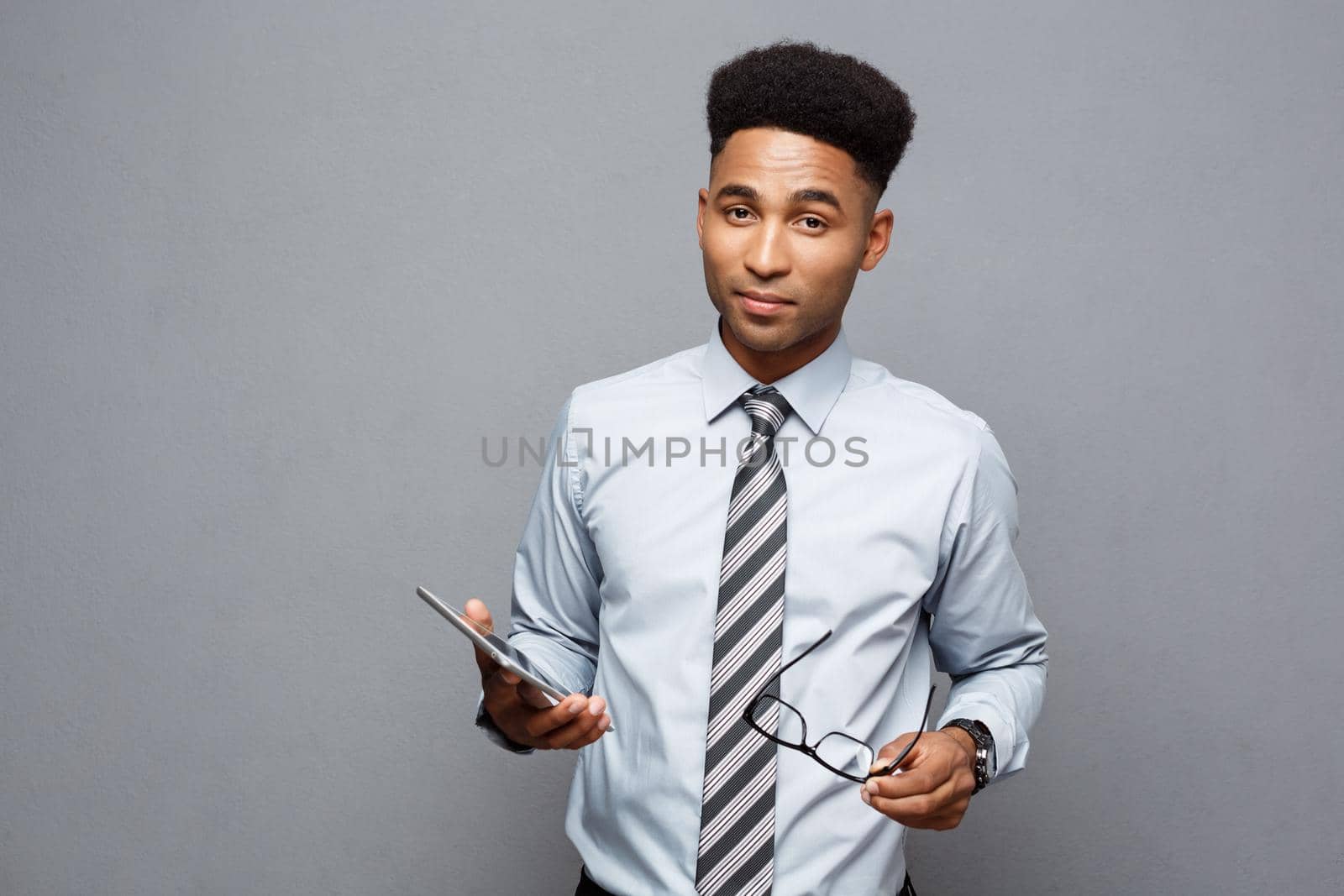 Business Concept - Happy handsome professional african american businessman holding digital tablet and talk with client. by Benzoix