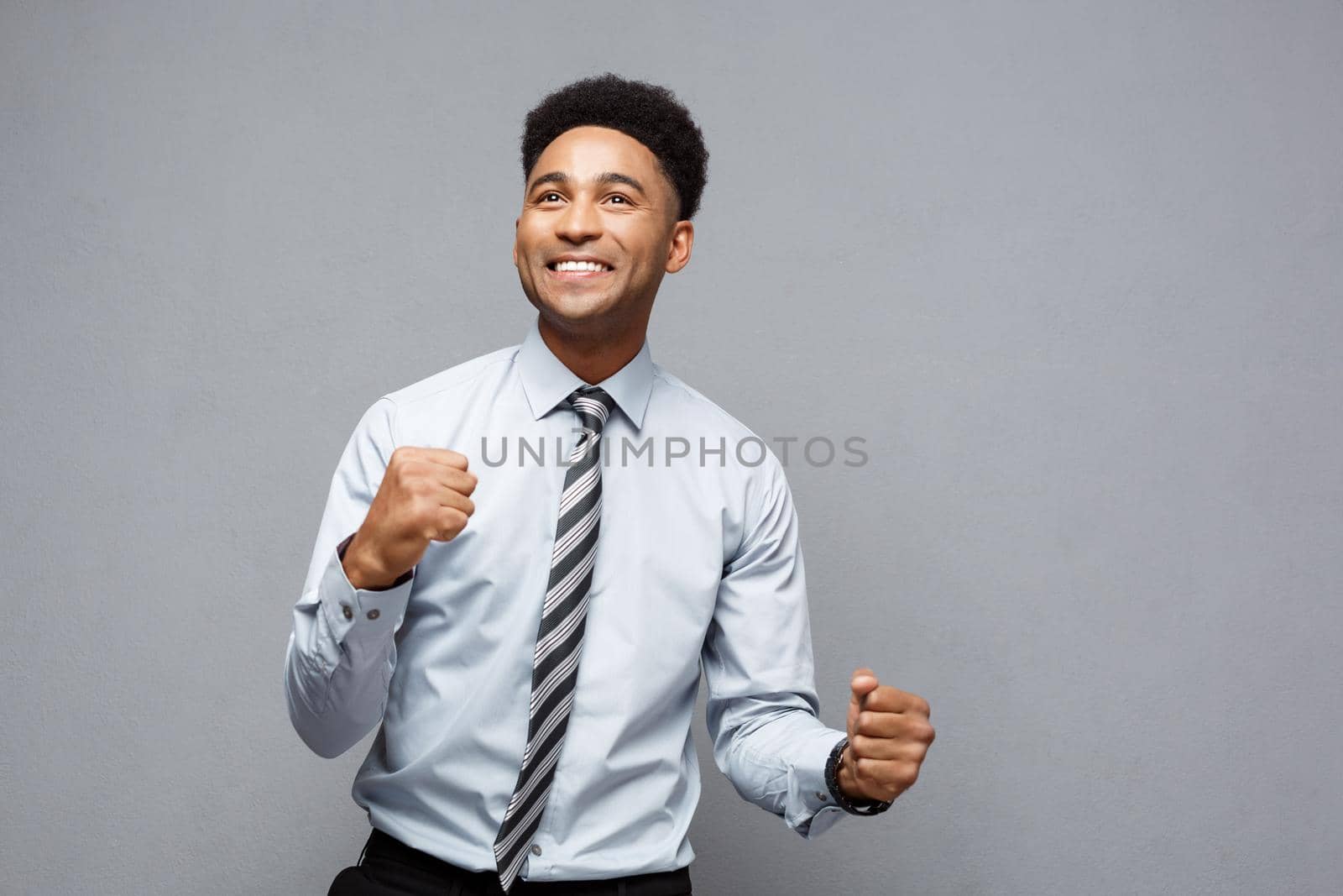 Business Concept - Confident happy young African American throwing fists in air celebrating for success projects. by Benzoix