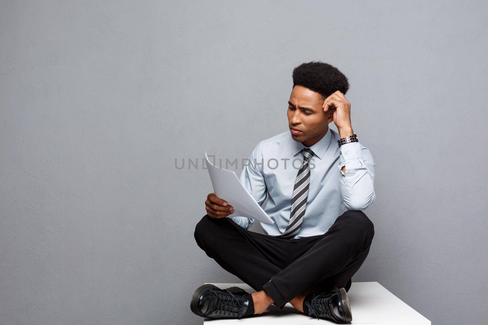 Business Concept - handsome young professional african american businessman serious reading paperworks