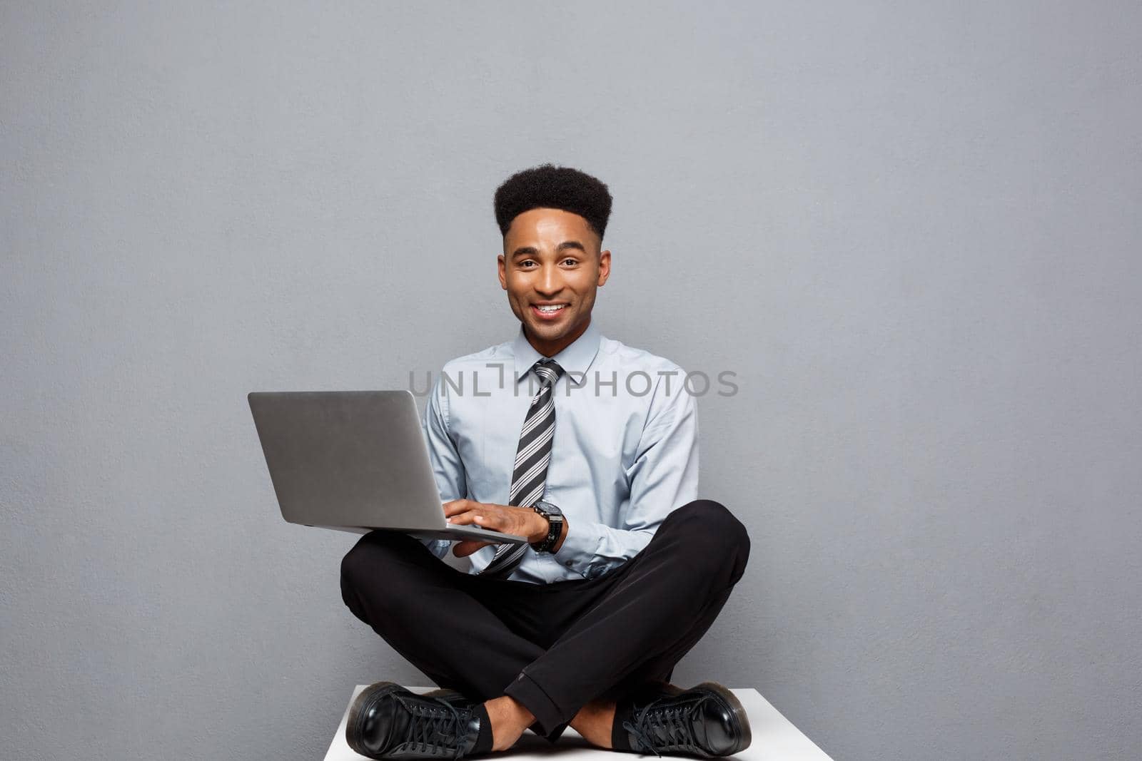Business Concept - Happy handsome professional african american businessman enjoy playing on labtop
