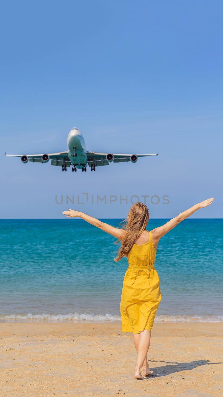 Woman have fun on the beach watching the landing planes. Traveling on an airplane concept. Text space. Island Phuket in Thailand. Impressive paradise. Hot beach Mai Khao. Amazing landscape VERTICAL FORMAT for Instagram mobile story or stories size. Mobile wallpaper by galitskaya
