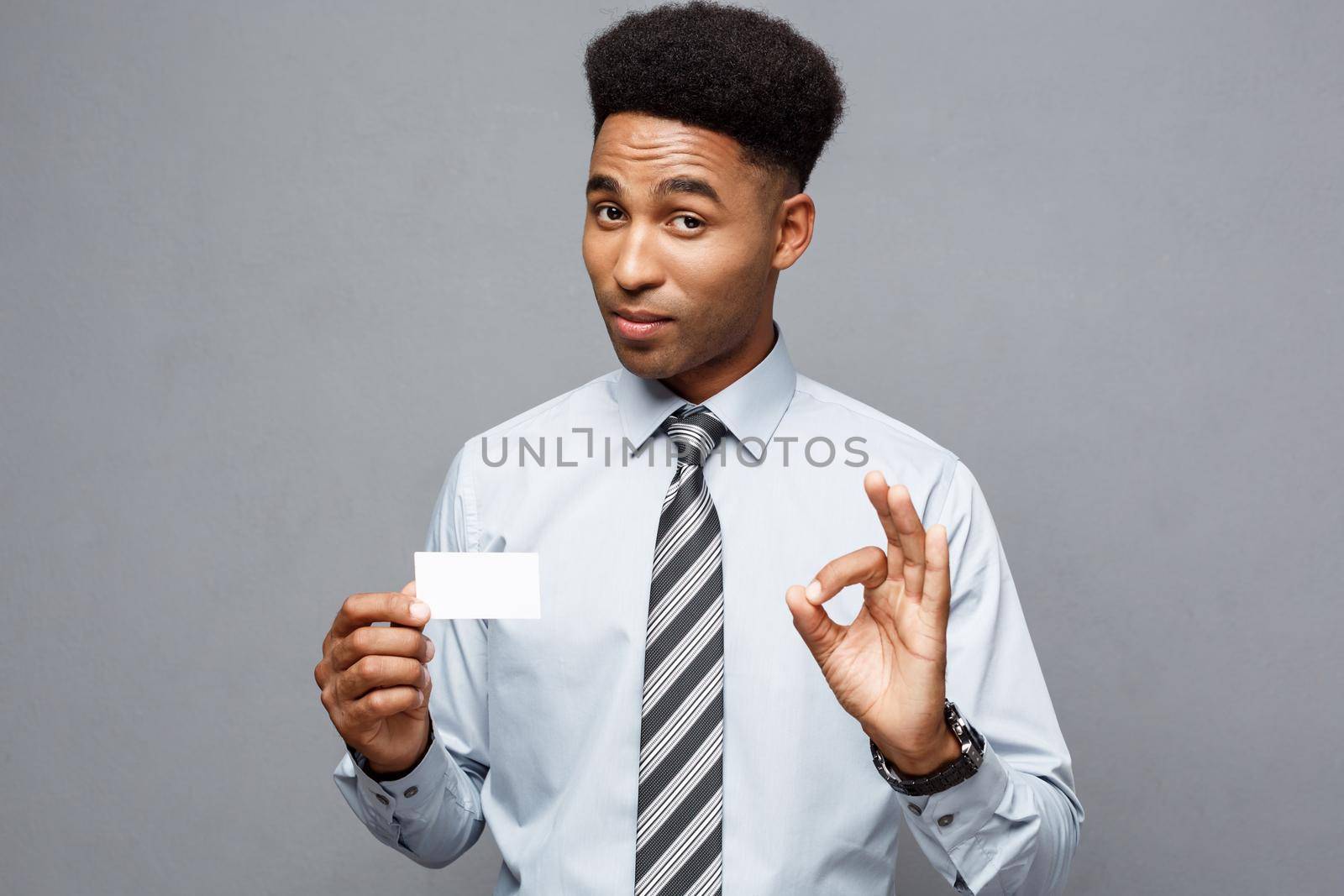 Business Concept - Happy handsome professional african american businessman showing name card to client. by Benzoix