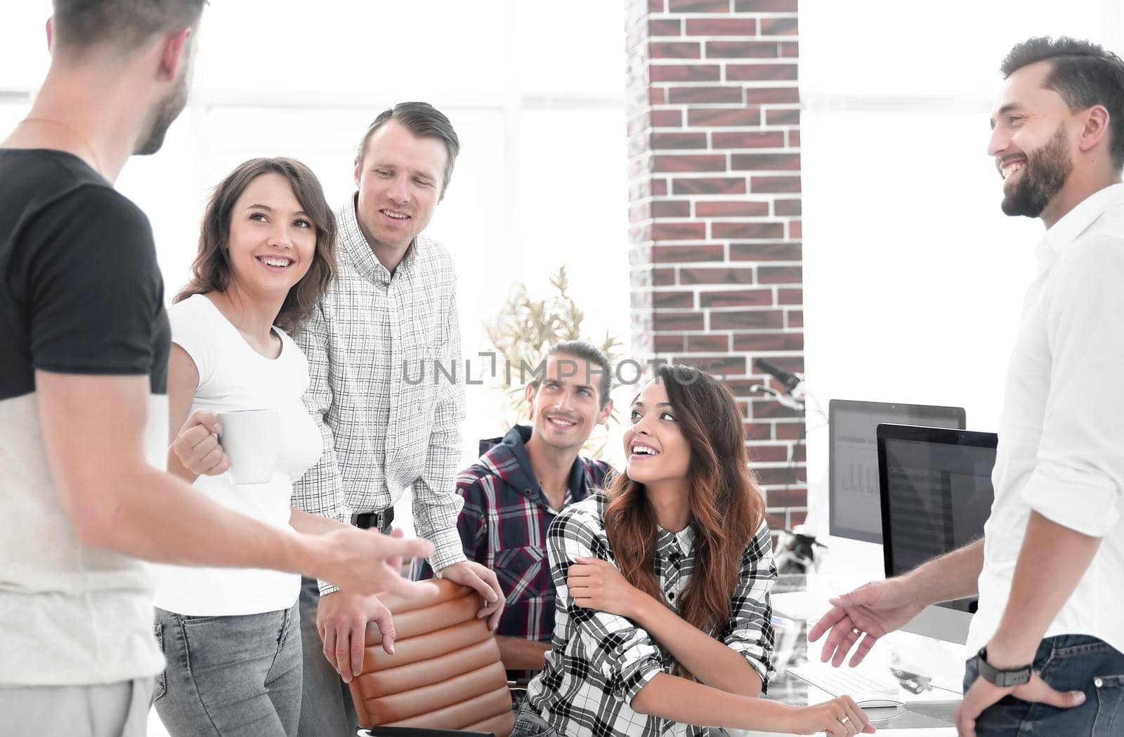 team of young employees discussing in creative office