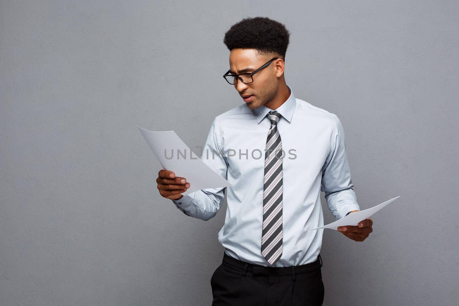 Business Concept - handsome young professional african american businessman concentrated reading on document paper