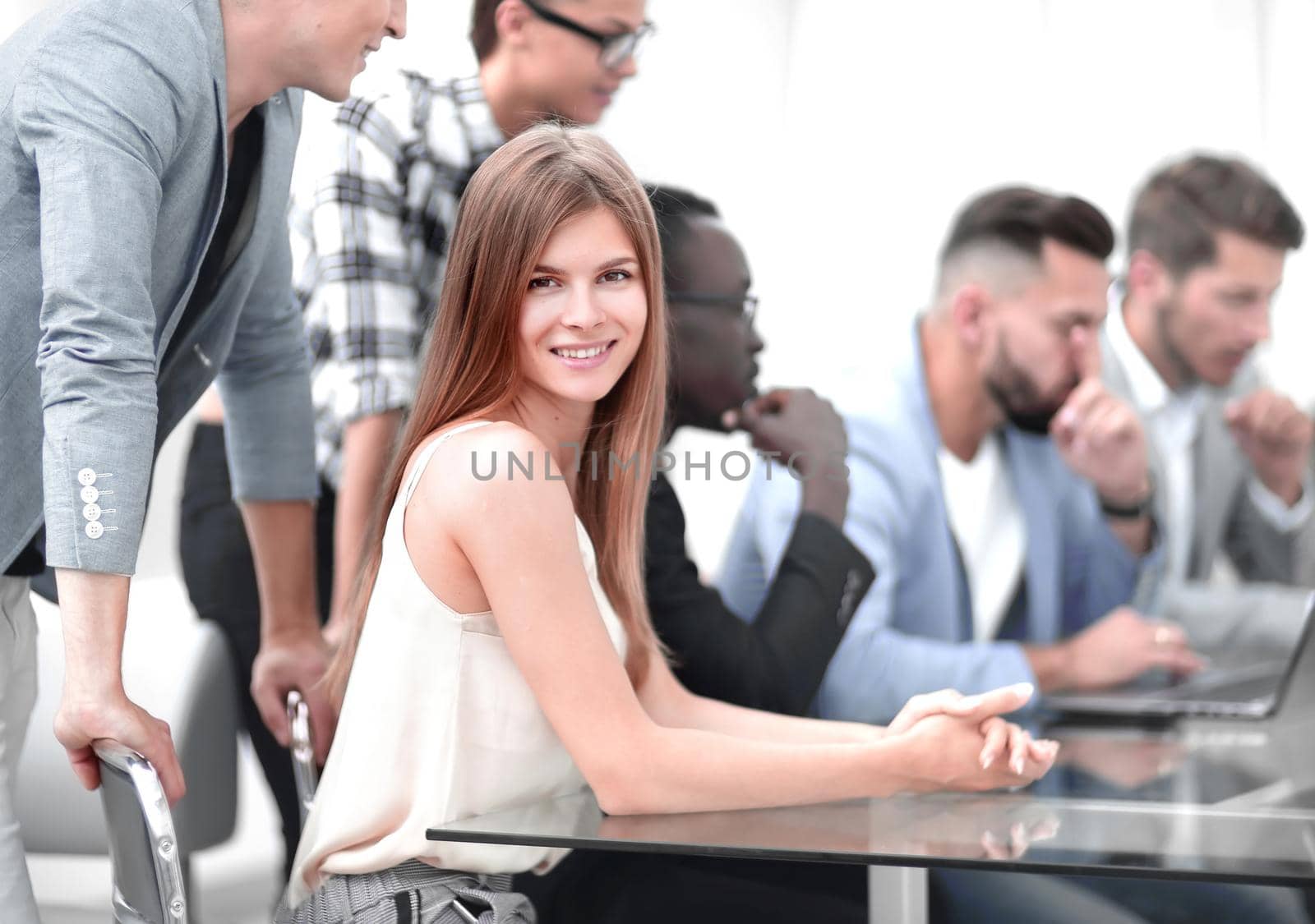 A group of business people listening to a colleague, addressing an office meeting