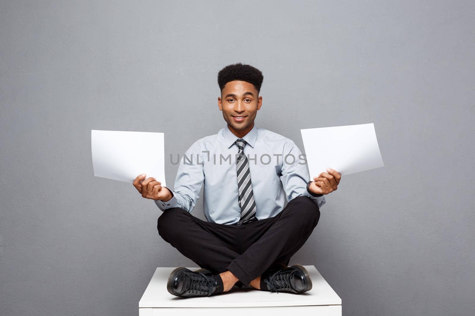 Business Concept - handsome young professional african american businessman holding report papers