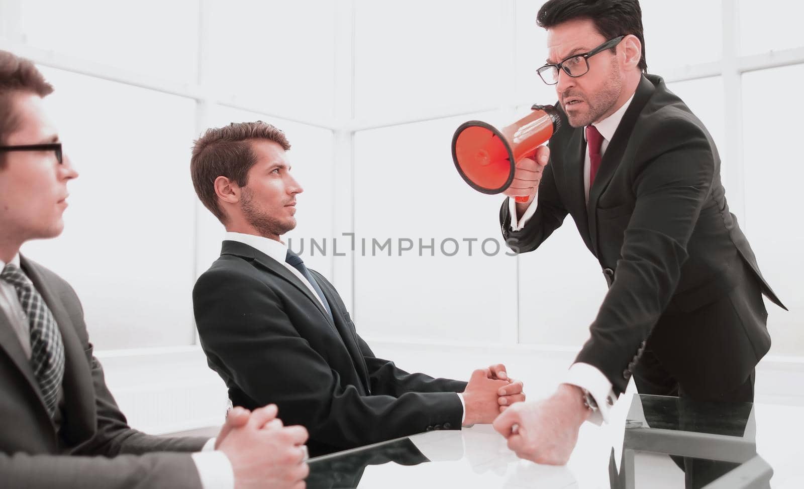 strict businessman with a megaphone at a meeting with employees.the business metaphor