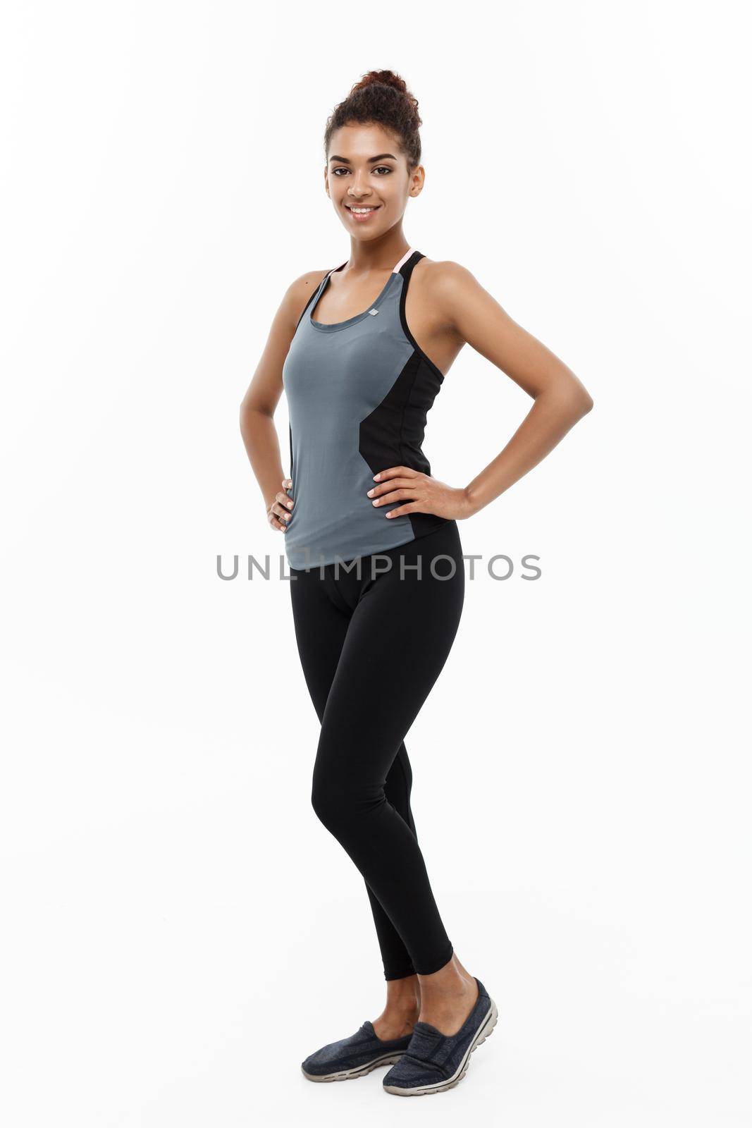 Healthy and Fitness concept - portrait of African American girl posing with fitness clothes over white studio background. by Benzoix