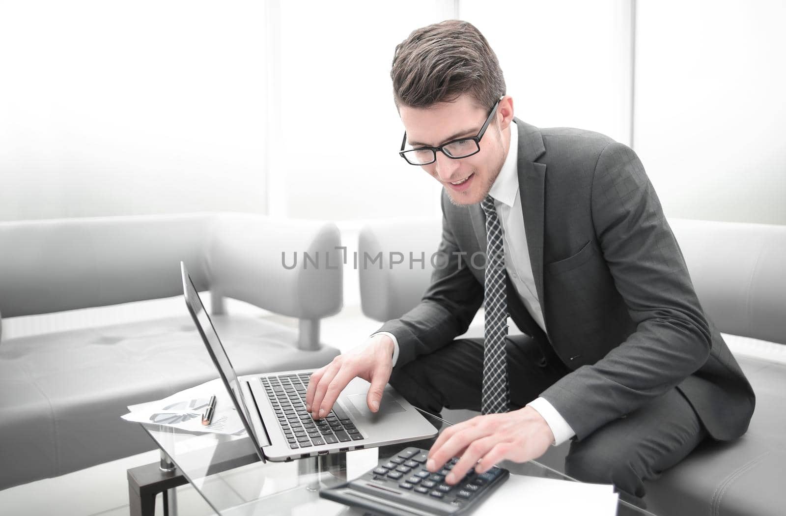 young businessman using calculator and laptop . photo with copy space