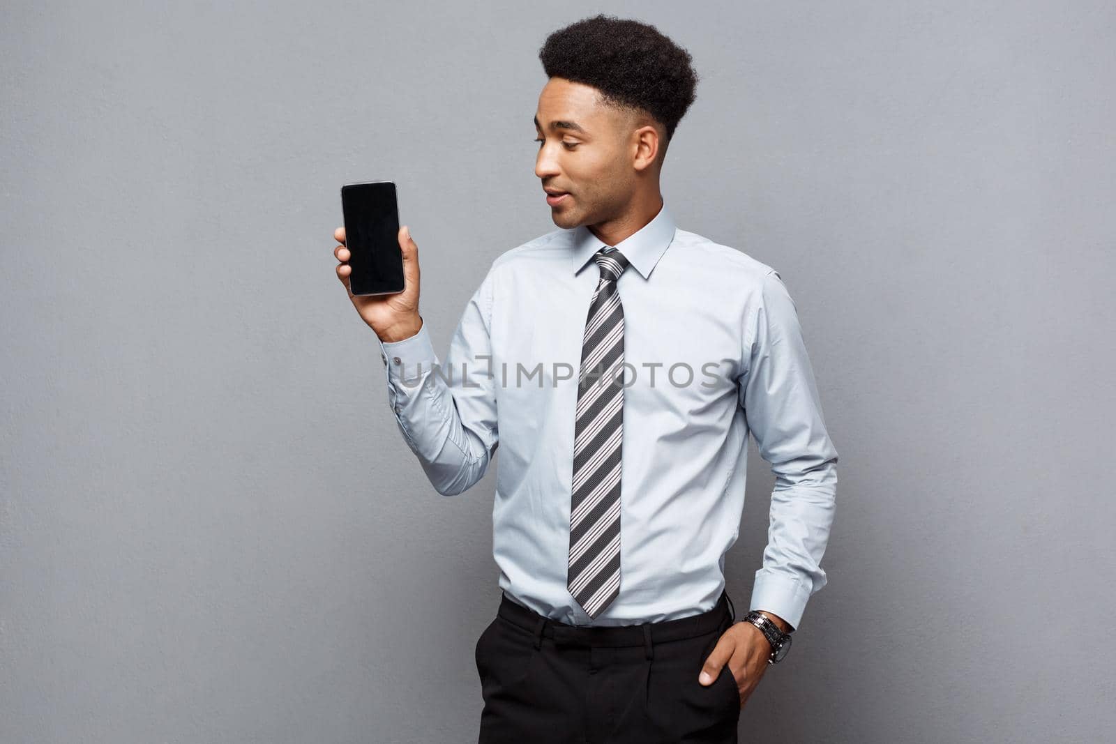 Business Concept - Happy handsome professional african american businessman showing mobile phone to client