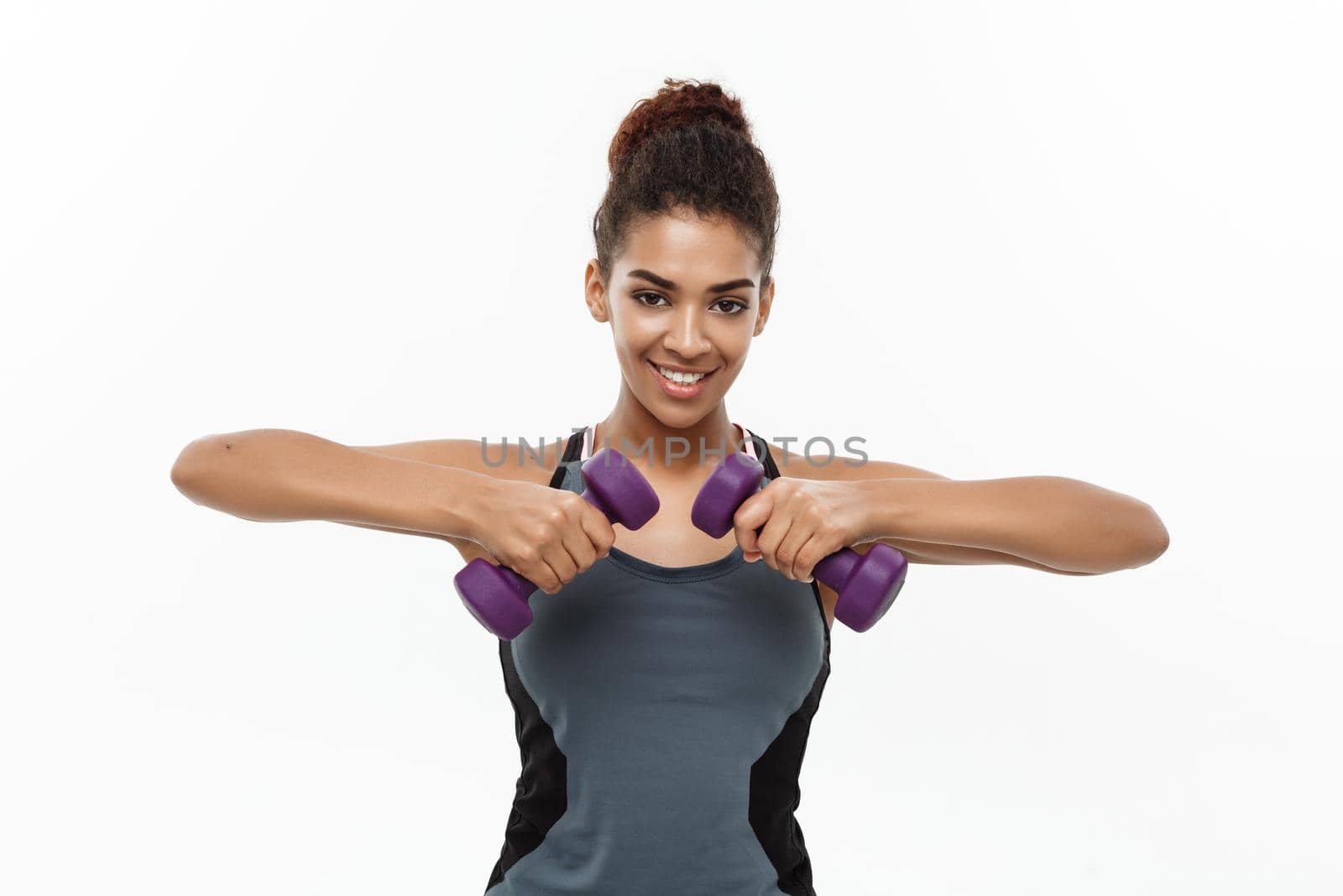 Healthy and Fitness concept - Beautiful American African lady in fitness clothes workout with dumbbell. Isolated on white background. by Benzoix