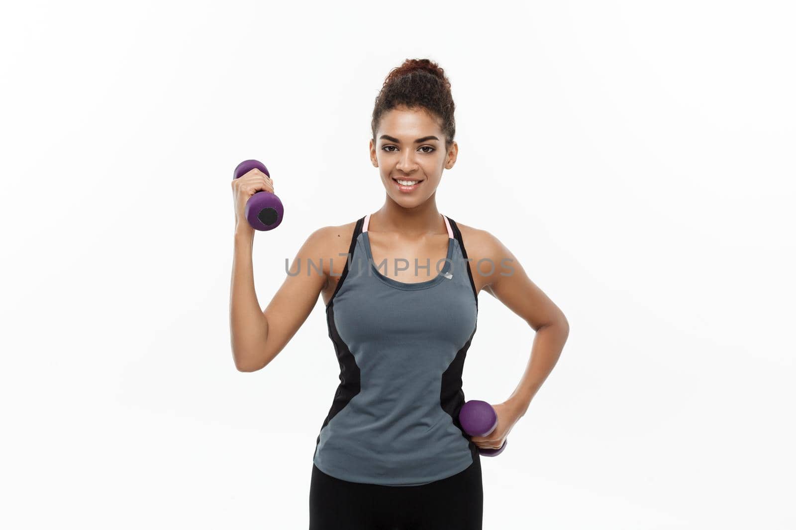 Healthy and Fitness concept - Beautiful American African lady in fitness clothes workout with dumbbell. Isolated on white background. by Benzoix