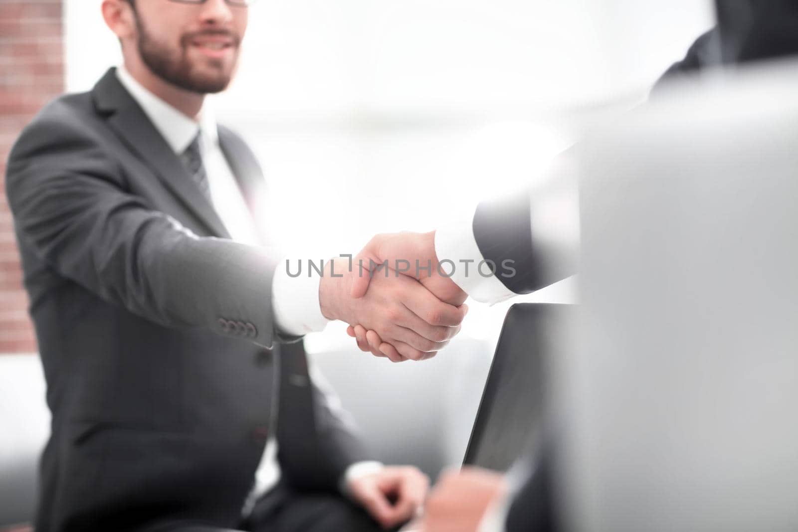 Confident businessman shaking hands at officce by asdf