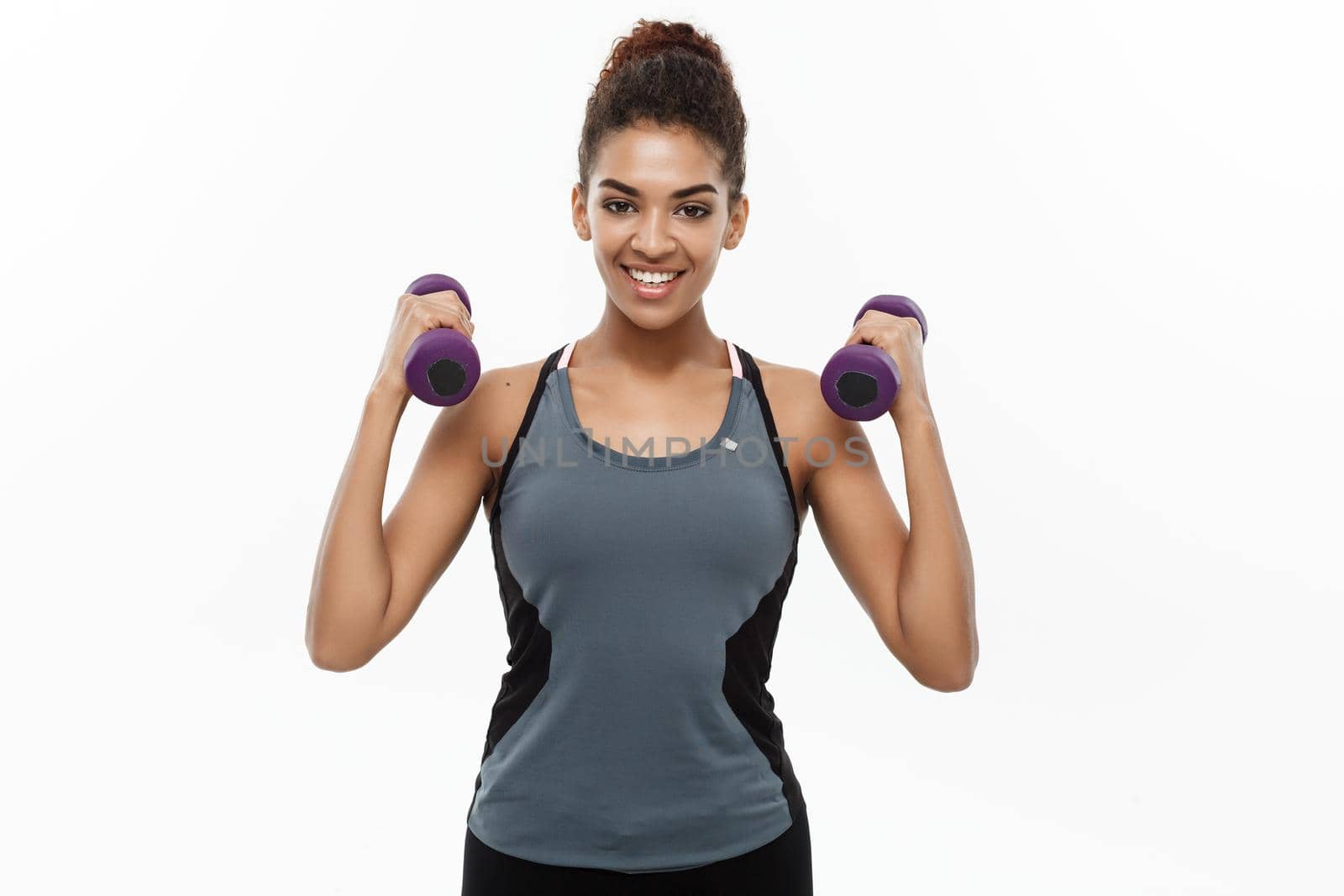 Healthy and Fitness concept - Beautiful American African lady in fitness clothes workout with dumbbell. Isolated on white background. by Benzoix